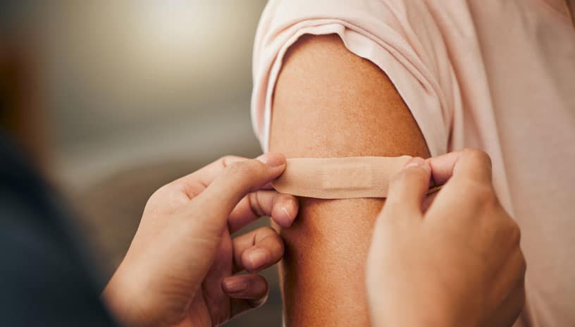 Nurse putting bandaid on patient