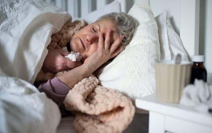 Woman with influenza laying in bed sick