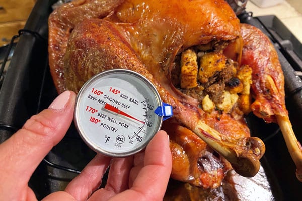 Checking the temperature with a meat thermometer to make sure the turkey  done Stock Photo